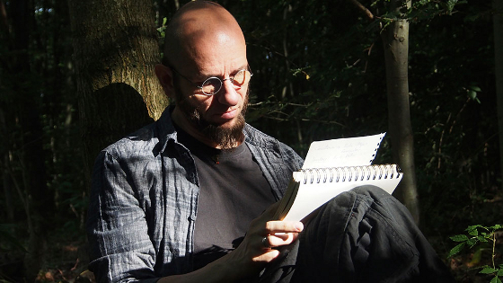Bernhard Herrman beim Schreiben im Wald
